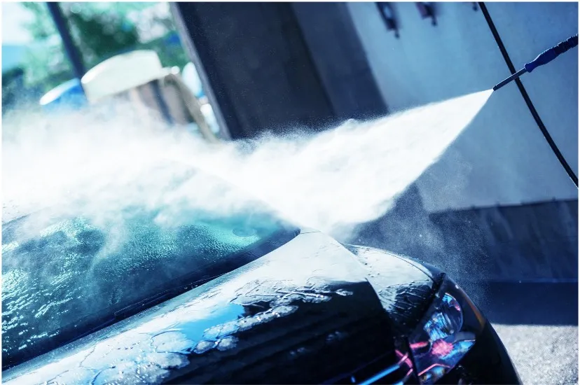 High-pressure jet cleaning the bonnet of a car