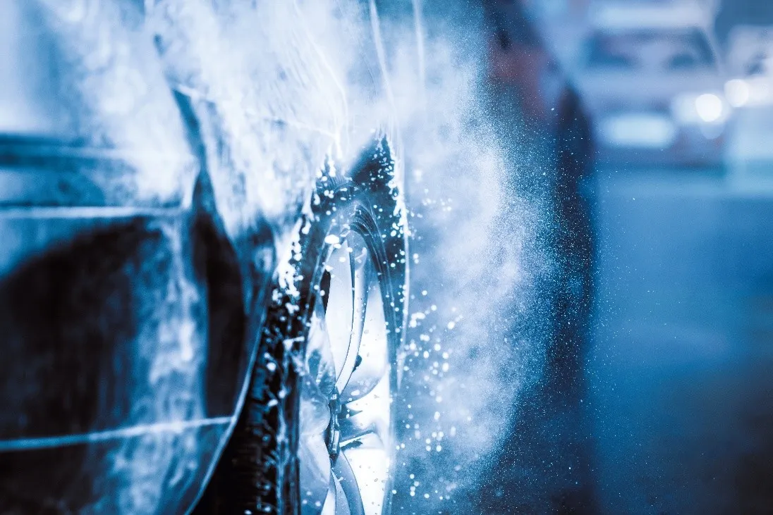High-pressure jet cleaning a car wheel during the pre-wash